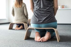2 mujeres sentadas en bancos de meditación