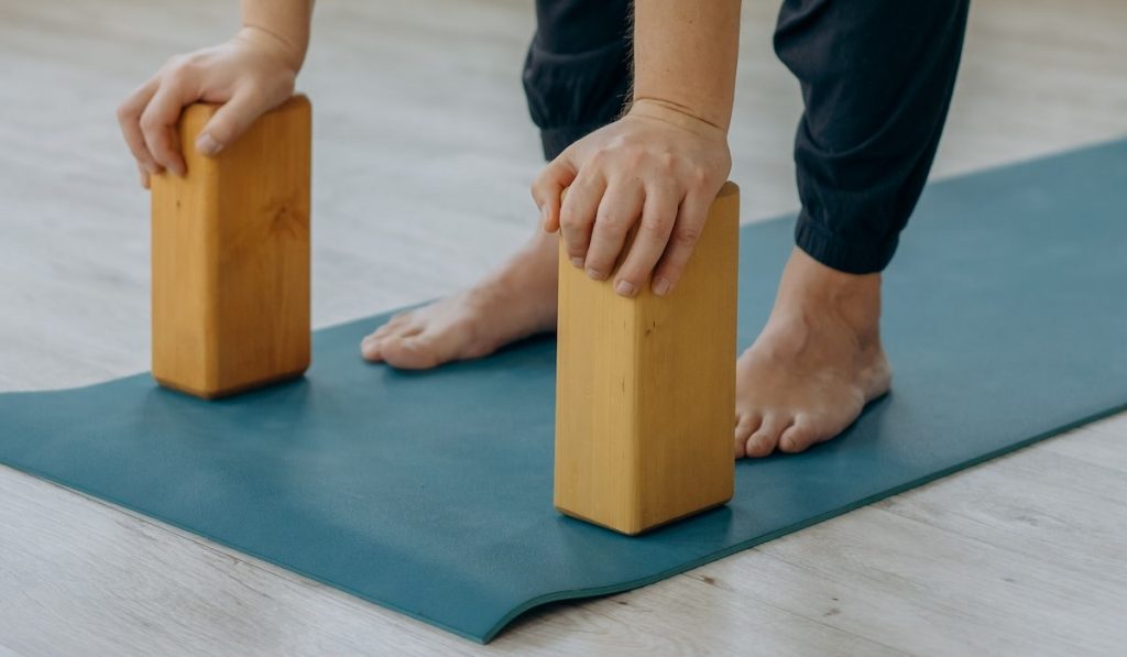 Persona con dos bloques de yoga en sus pies